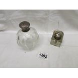 A glass scent bottle with silver top and a glass inkwell.