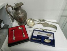 A silver plated jug, cutlery etc.