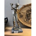 A silver plated figure of a golfer