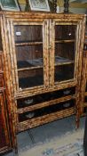 A bamboo cabinet having 2 doors and 2 drawers.