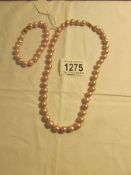 A pink pearl necklace and bracelet.