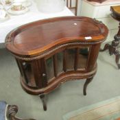 A mahogany kidney shaped display cabinet.