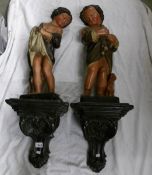 A pair of Victorian figures of children complete with wall brackets.