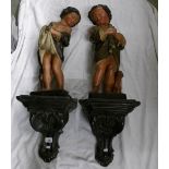 A pair of Victorian figures of children complete with wall brackets.