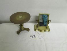 A miniature brass toilet mirror and a miniature brass trivet (possibly travellers samples).