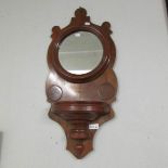 A small mahogany wall mirror with shelf.