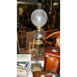 An unusual Victorian oil lamp on brass base with glass column, glass font and acid etched shade.