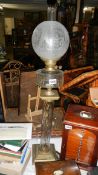 An unusual Victorian oil lamp on brass base with glass column, glass font and acid etched shade.