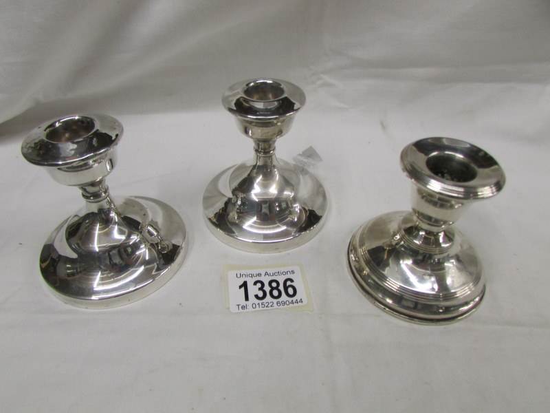 3 squat silver candlesticks.