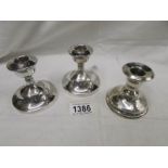 3 squat silver candlesticks.