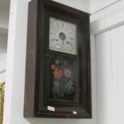An American wall clock with floral painted panel.