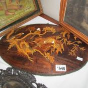 An oval wall plaque inlaid with birds.