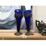 A pair of blue art glass vases in metal frames