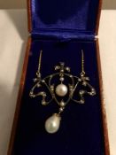 A necklace set with diamonds, seed pearls and pearls in a brown box.