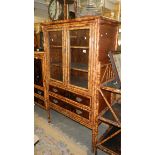 A bamboo cabinet having 2 glazed doors and 2 bottom drawers.