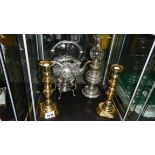 A silver plate kettle on stand, a pair of brass candlesticks and a plated oil lamp.