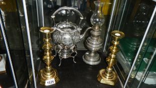 A silver plate kettle on stand, a pair of brass candlesticks and a plated oil lamp.