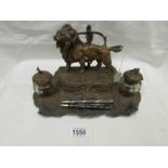 A 19th century metal desk stand surmounted lion and with 2 inkwells.