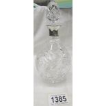 A cut glass liquor decanter with silver collar.