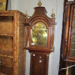 A brass faced Grandmother clock in working order.