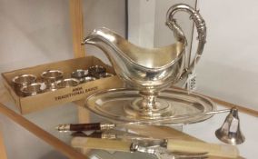 A silver plate saucer boat, fish servers, candle snuffer and 8 napkin rings.