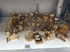 A collection of miniature gold plated clocks in various shapes