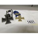 A German 25 year long service cross + oak leaves and an Iron cross first class 1914 version.