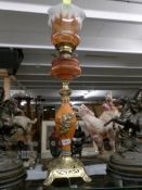 A good Victorian oil lamp on ornate base with amber glass font and original shade (possibly Galle').