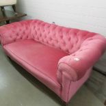 A pink Chesterfield sofa.