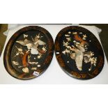 A pair of oval lacquered plaques with applied mother of pearl eagles.