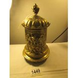 A heavy brass tobacco jar with mask decoration.
