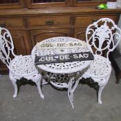 A metal garden table and 2 chairs.