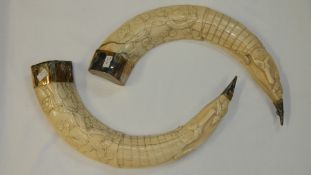 A pair of antique carved ivory tusks - with silver metal on top and bottom and carved with