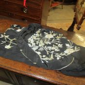 A black kimono with silver coloured embroidery.