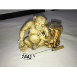 A faux ivory monkey table cigarette lighter.