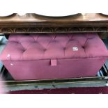 A pink button upholstered blanket box