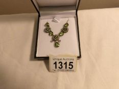 A necklace set with peridot, seed pearls and diamonds,