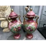 A pair of floral decorated twin handled lidded vases.A/F