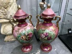 A pair of floral decorated twin handled lidded vases.A/F