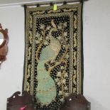 A peacock wall hanging on pole.