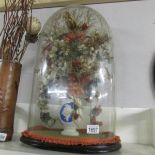 A floral arrangement under glass dome.