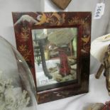 A small mirror in lacquered frame.