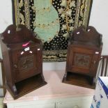 A pair of mahogany wall cupboards with carved floral decoration.