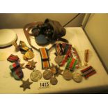 A quantity of medals with ribbons and a pair of military binoculars.