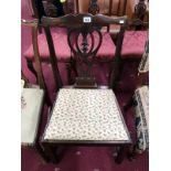 A Victorian dining chair with a scrolled back and a foliage pattern seat