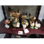 A shelf of chicken ornaments and salt and peppers