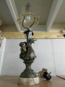 A table lamp with cherub base and glass shade.