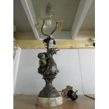 A table lamp with cherub base and glass shade.