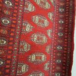 A red patterned eastern rug, approximately 160 x 95.5 cm.
