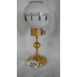 A globe shaped clock on stand, in need of repair.